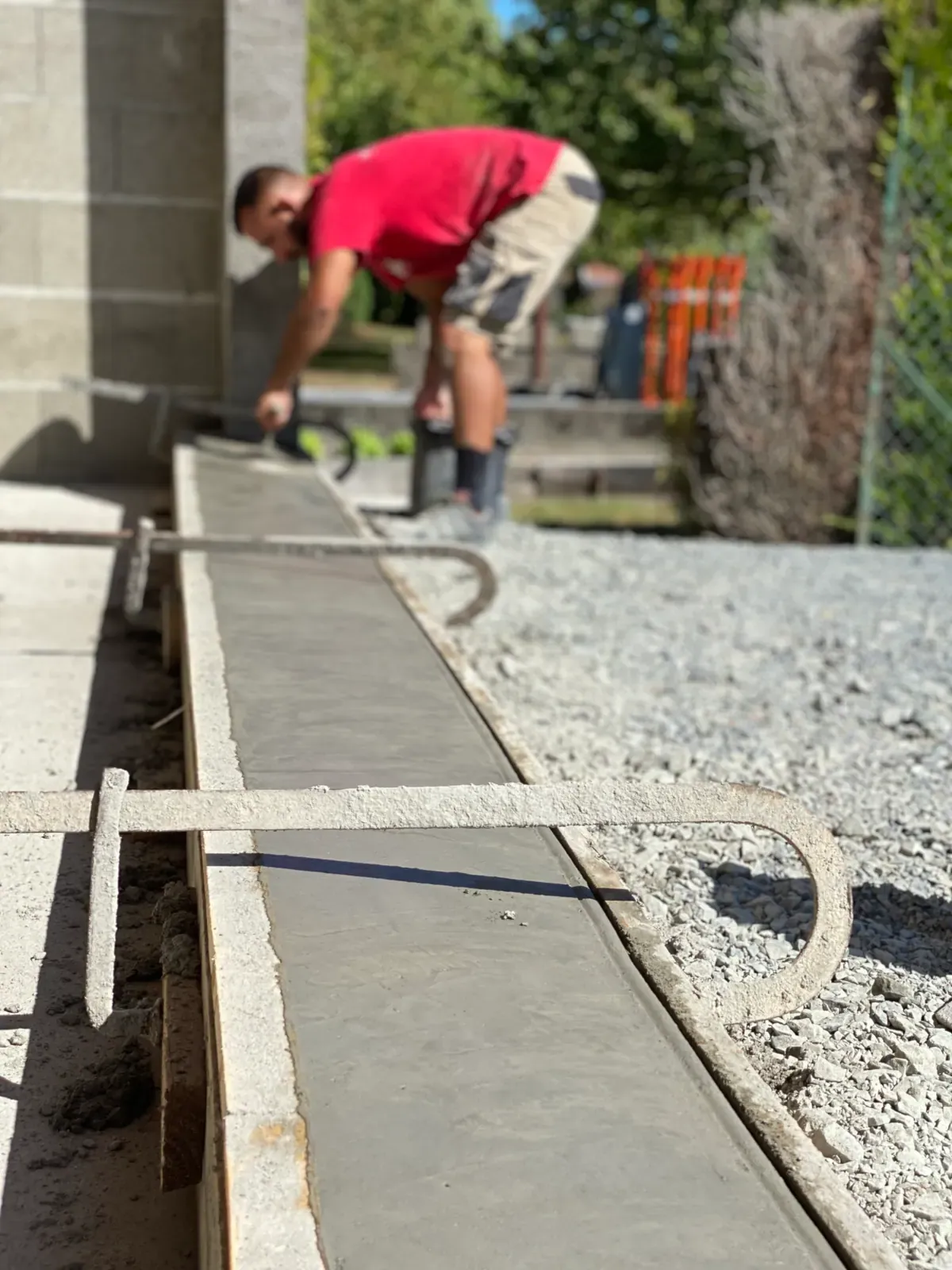 Artisan Cayenne Construction lissant une longrine béton sur chantier