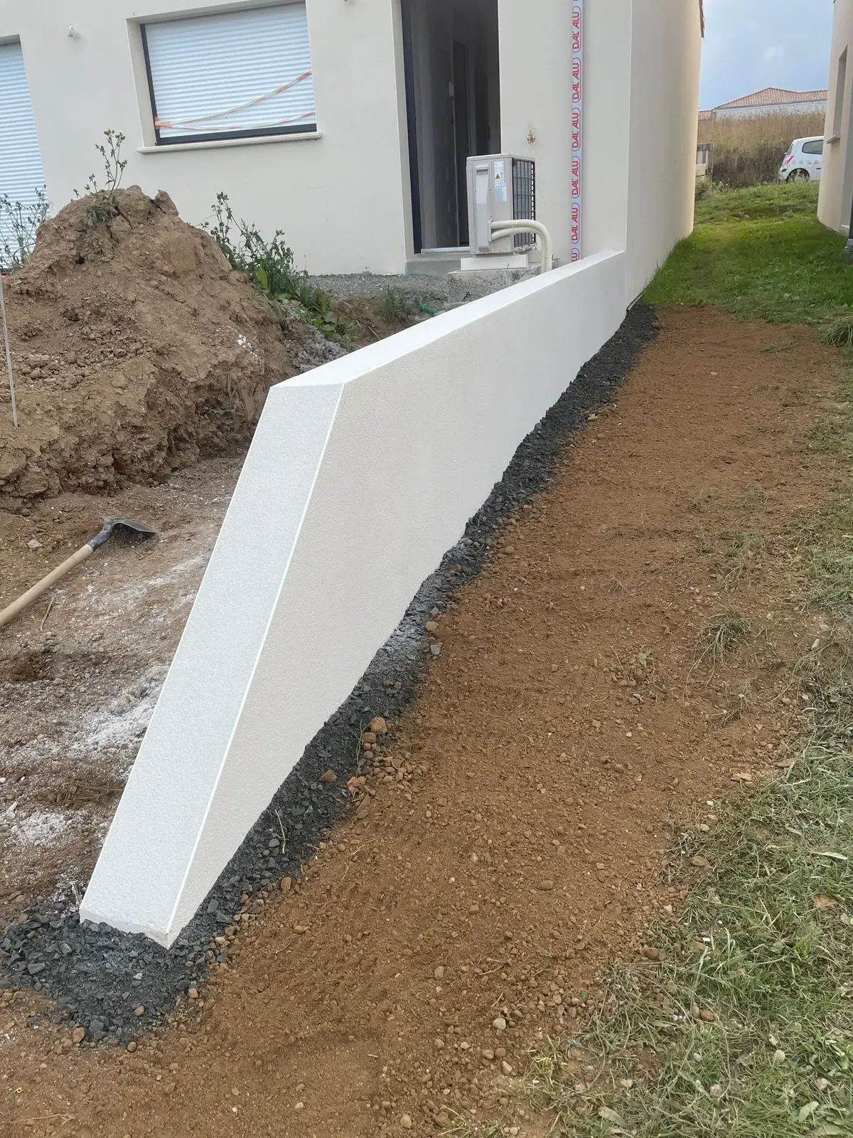 Muret enduit blanc finition propre devant une maison