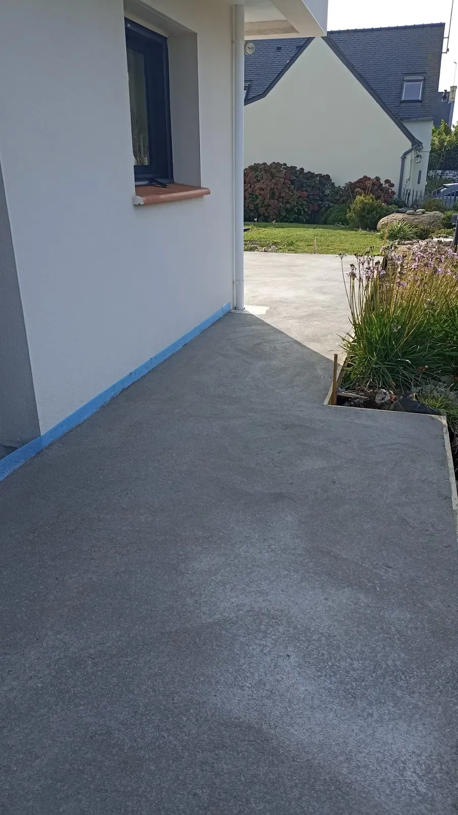 Terrasse béton lissé finie en bord de jardin