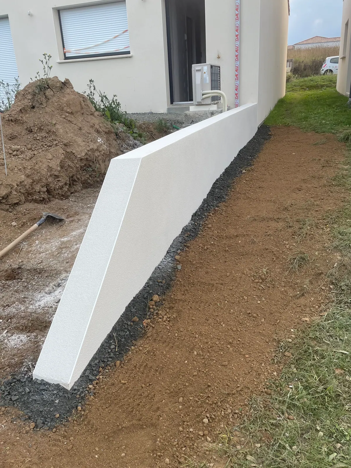 Muret enduit blanc finition propre devant une maison